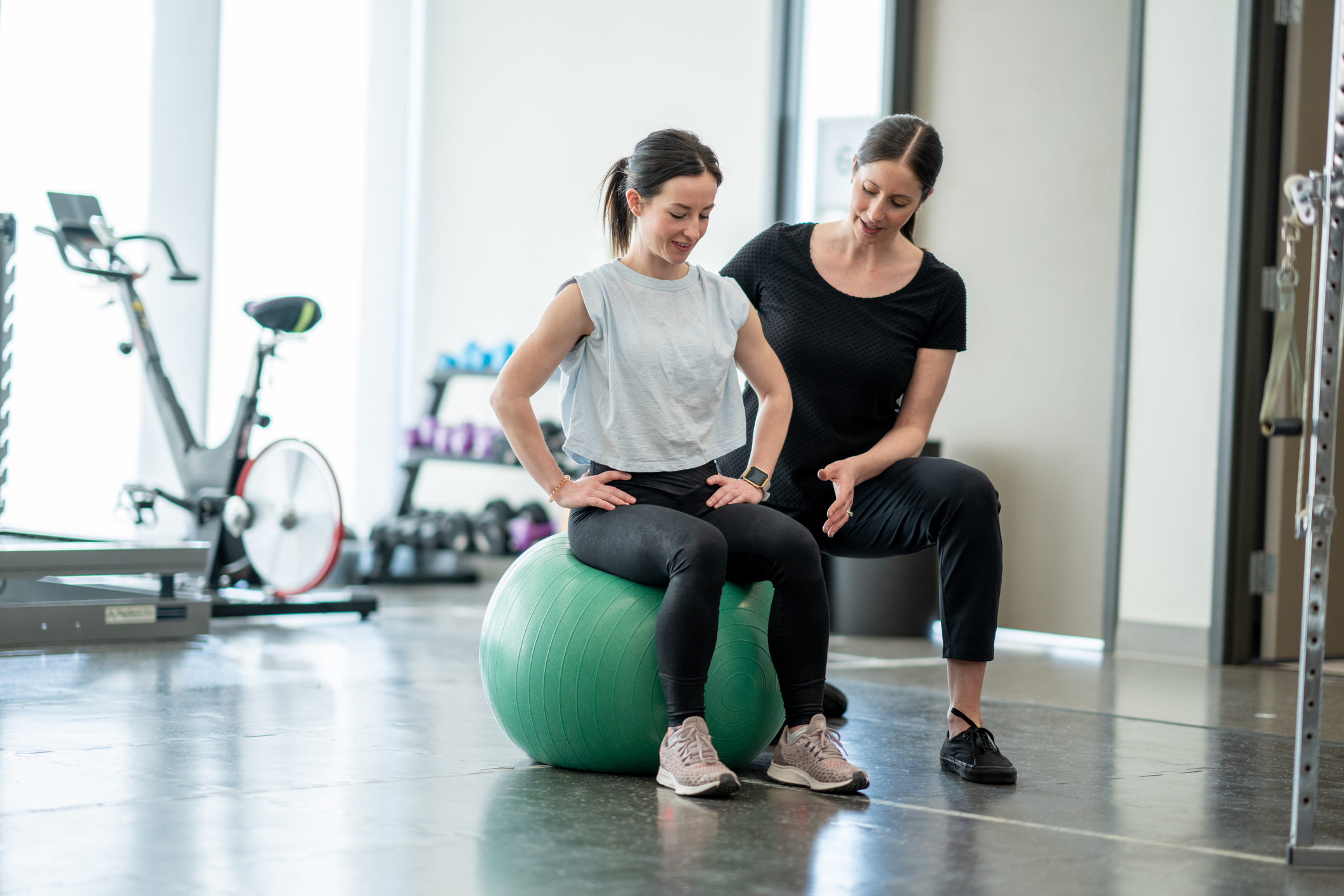 Woman on exercise ball receiving therapy