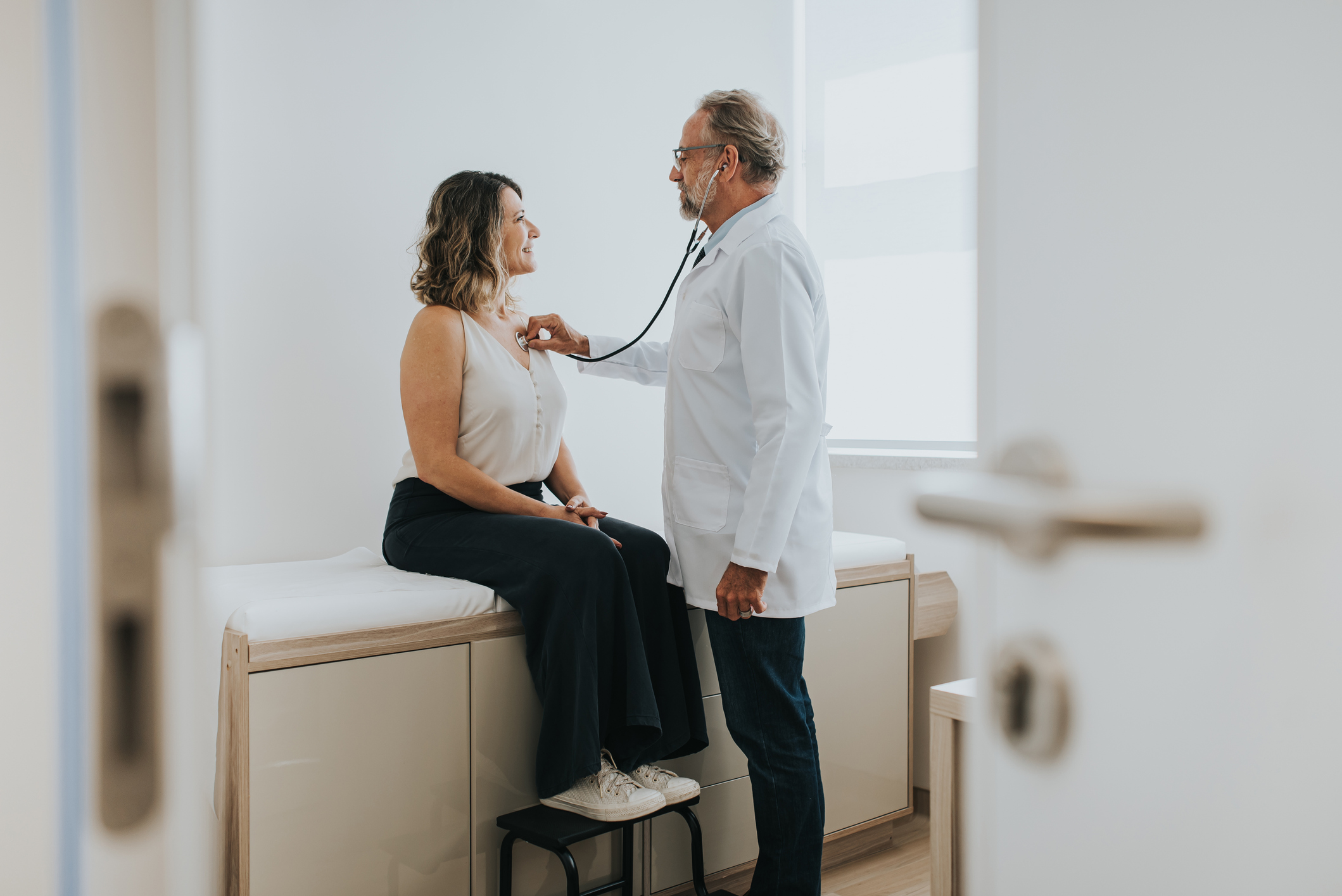 Doctor checking woman's heartbeat