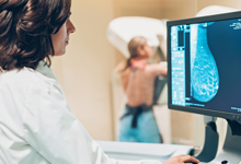 Nurse Looking At Computer During Mammogram