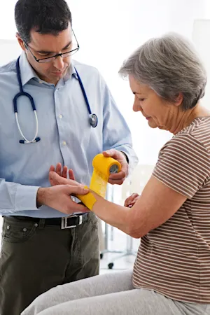 Doctor wrapping the wrist of an older woman