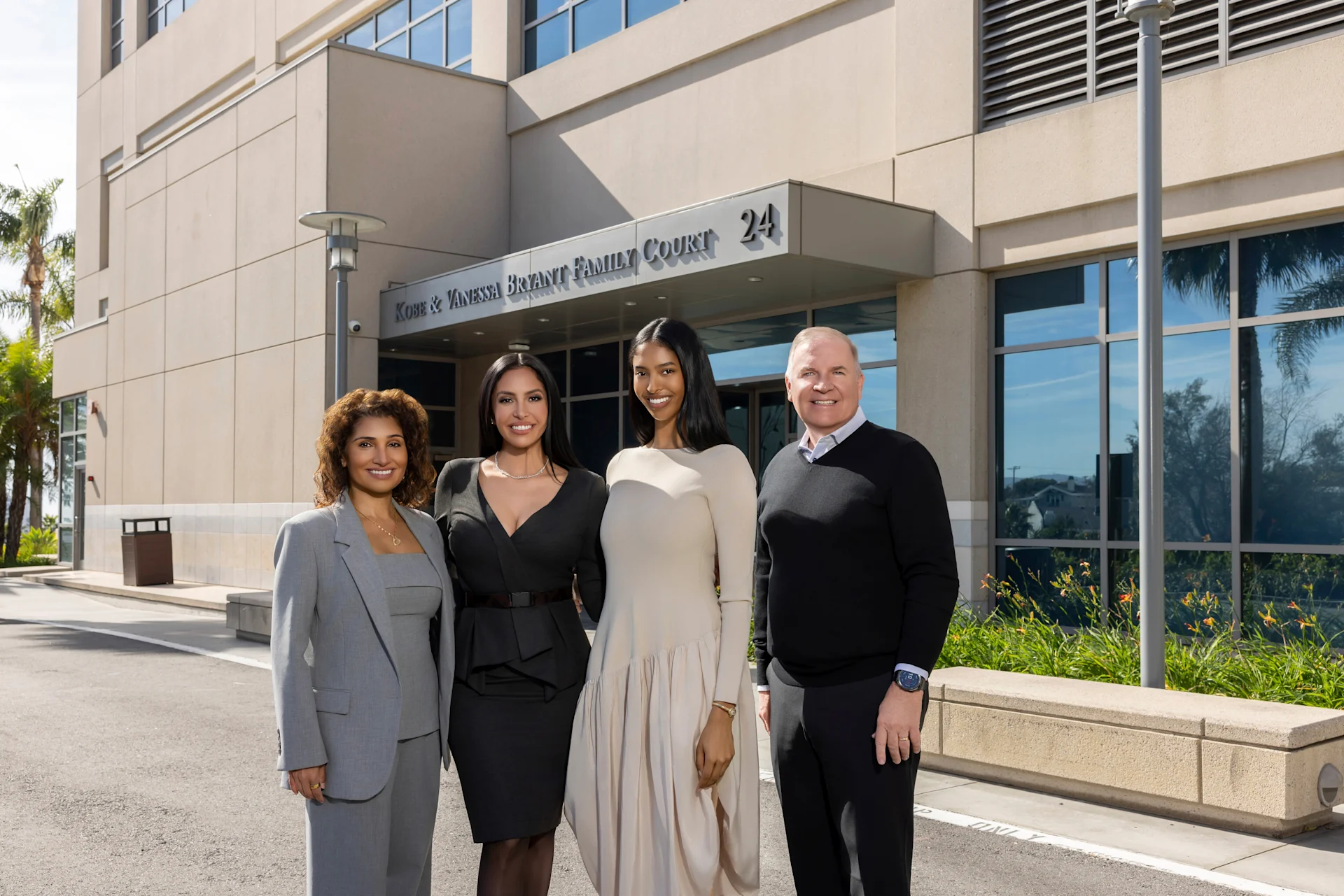 Three women and a man stand outside a hospital building