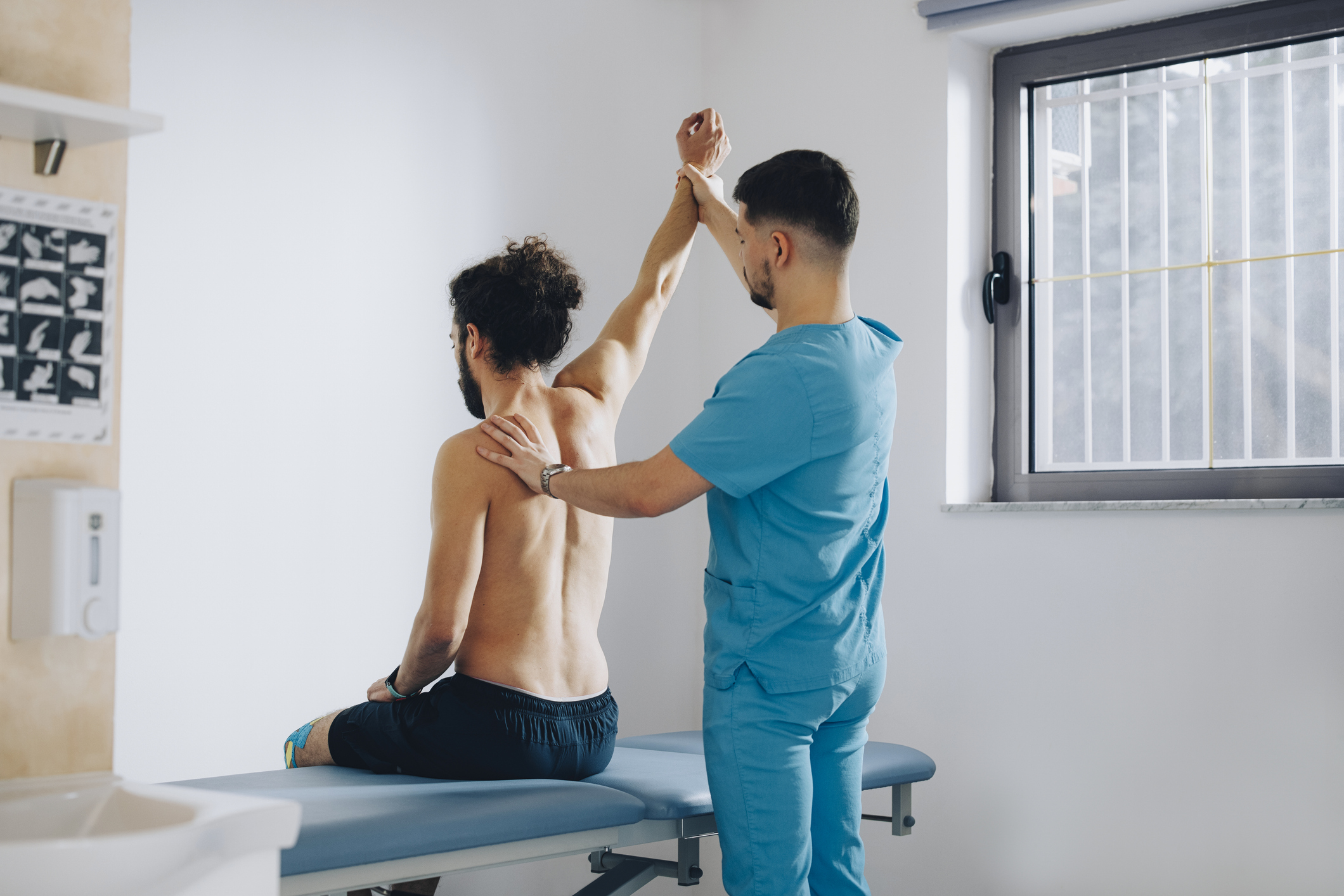 Physician examining patient's back or spine