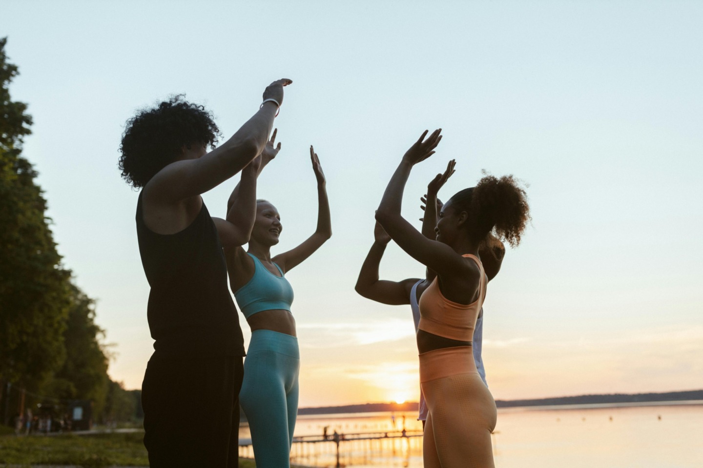 Women doing yoga next to water