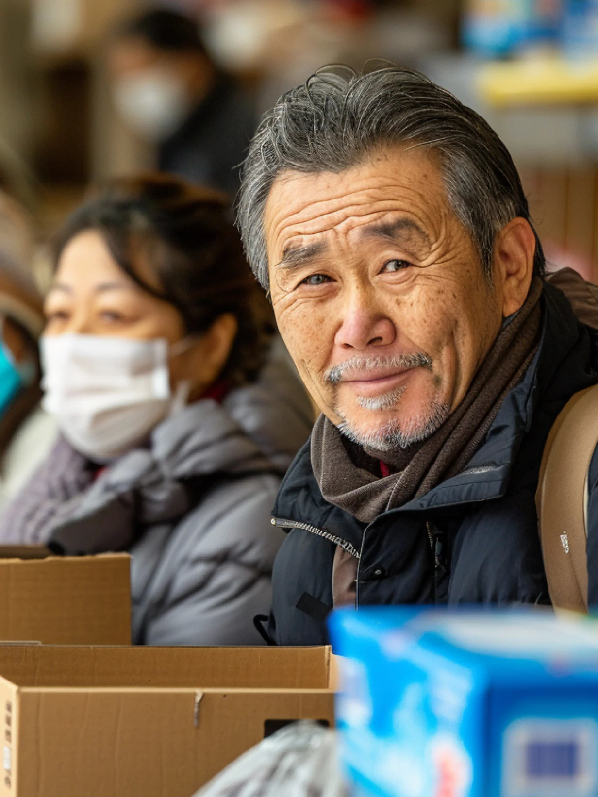 Smiling man holding food pantry box