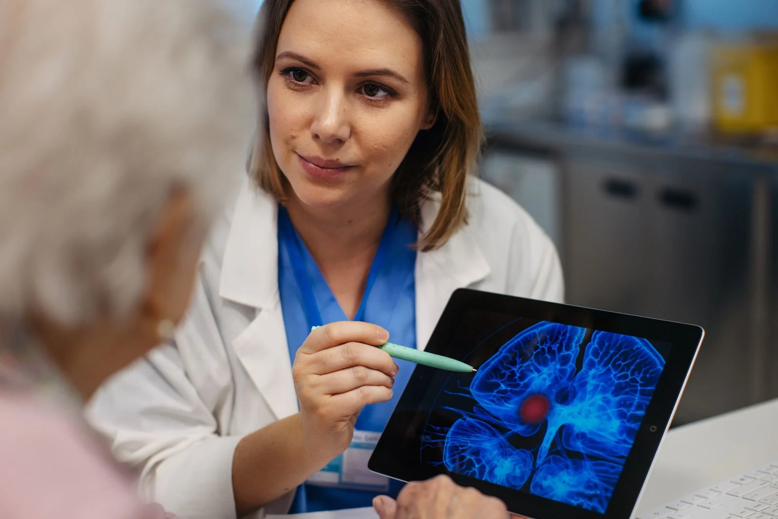 A doctor shows a patient a brain scan that reveals the cause of her headache