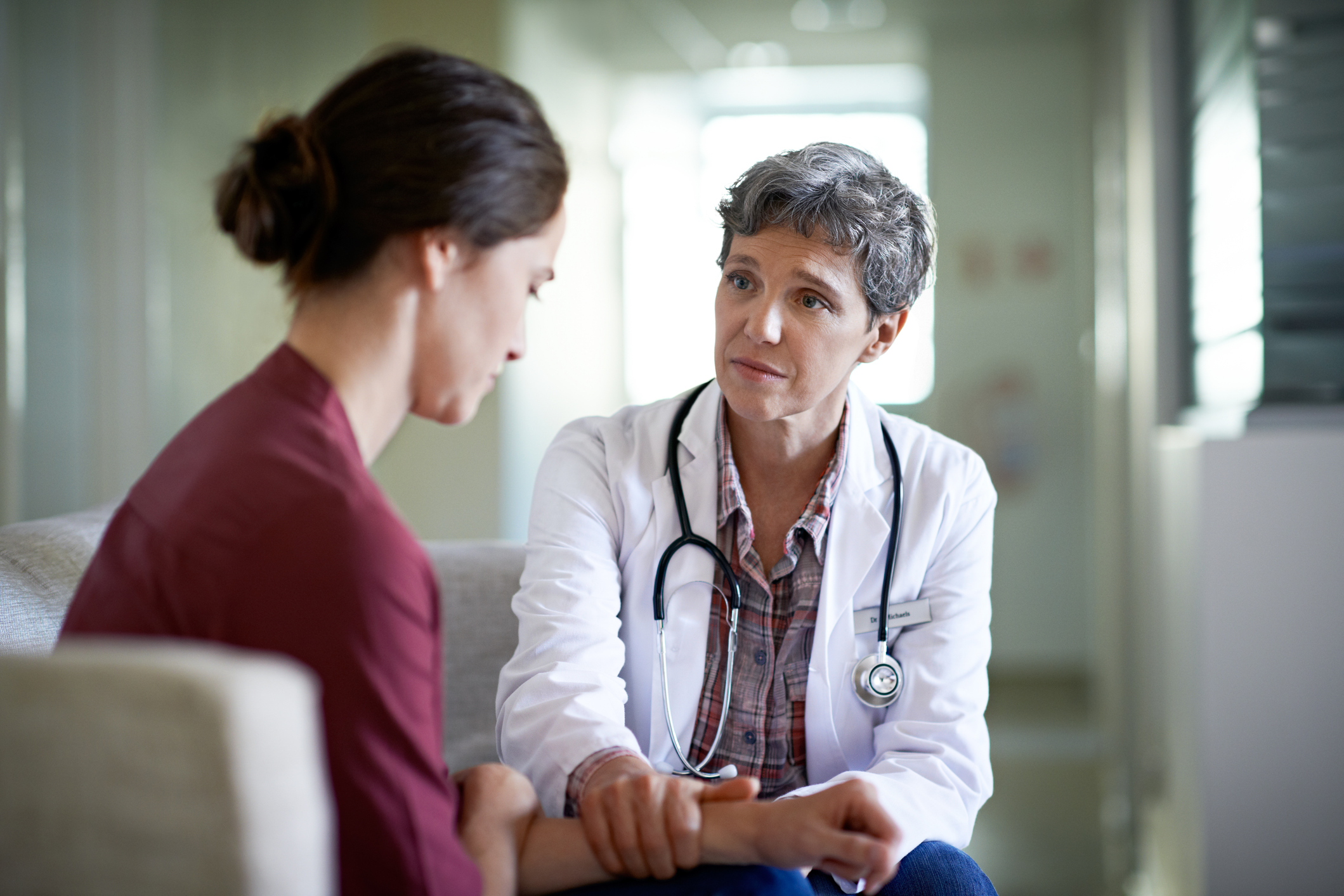 Female doctor with stethoscope talking to patient