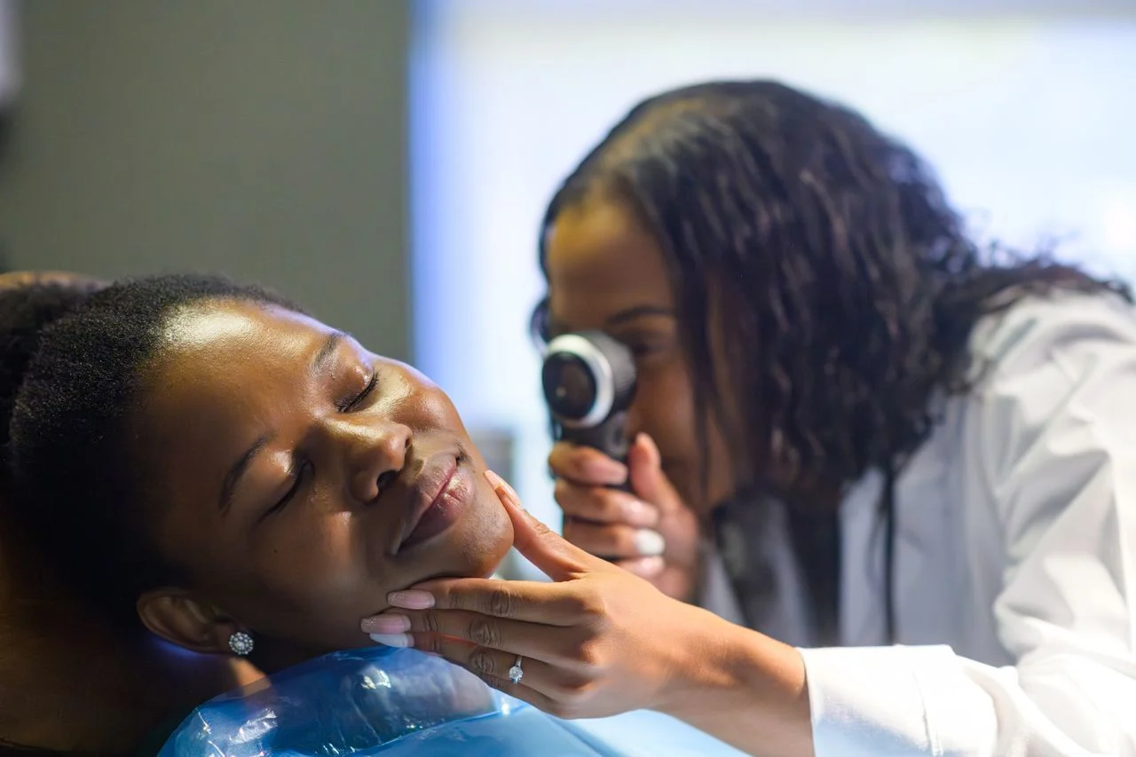 Checking woman's face for melanoma