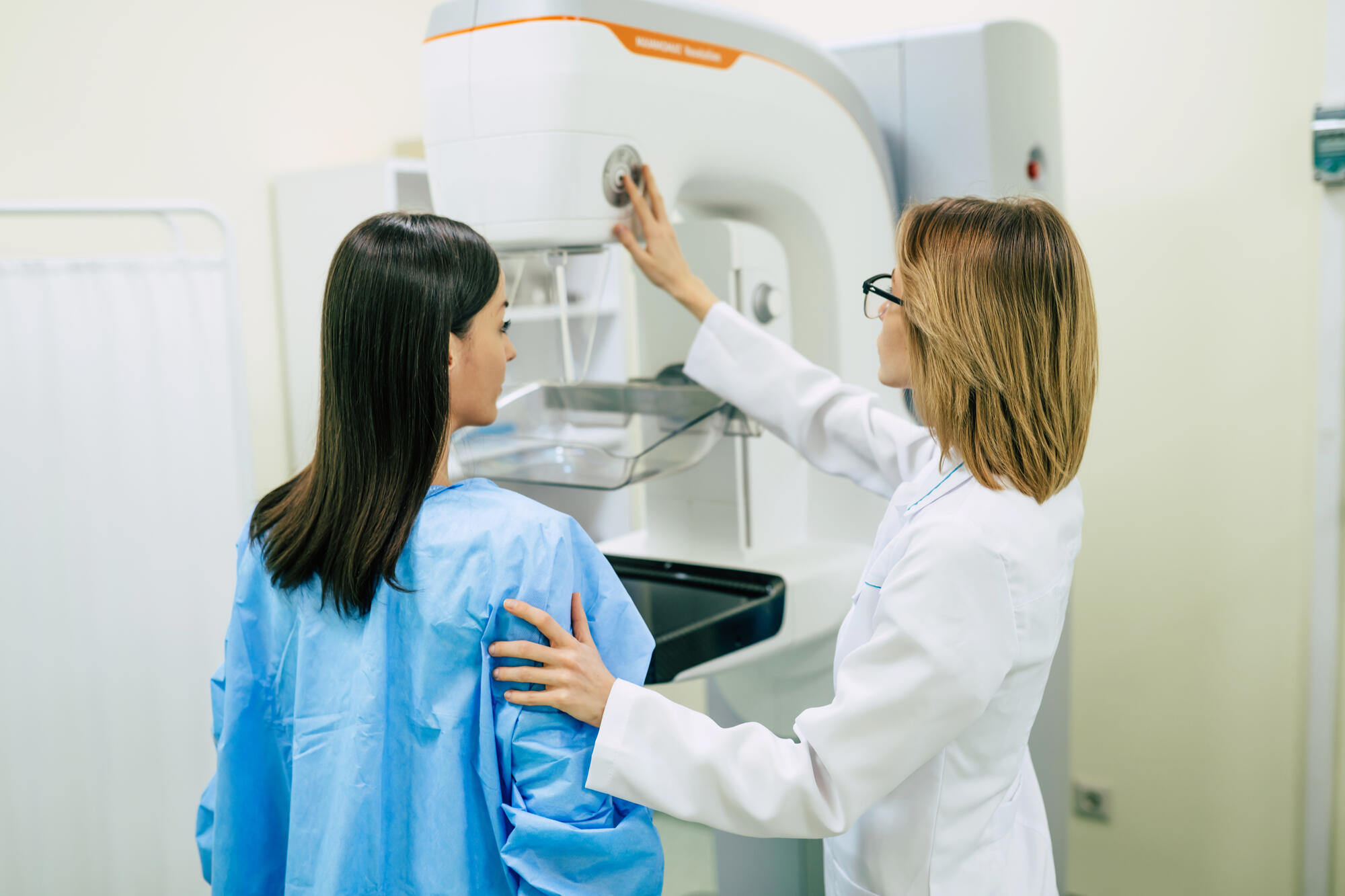 A doctor prepares a patient for a mammogram