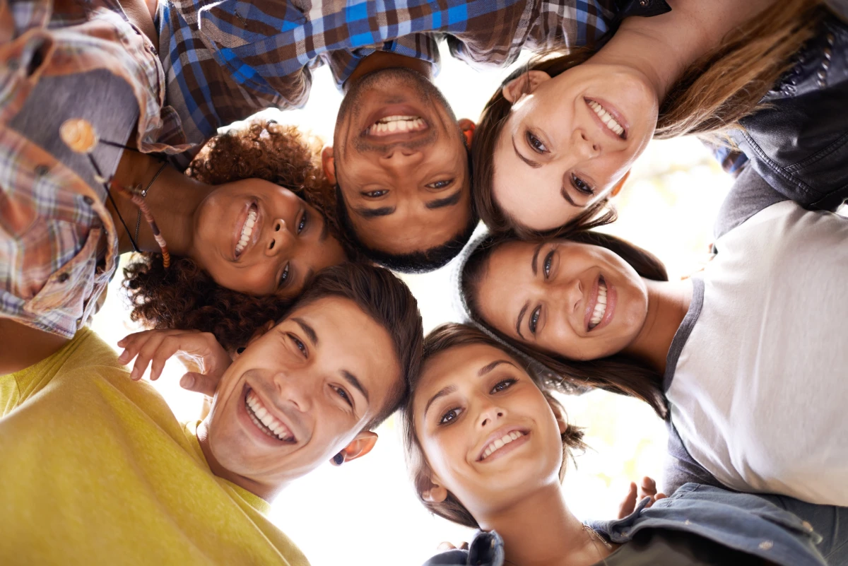 Young adults circled up smiling