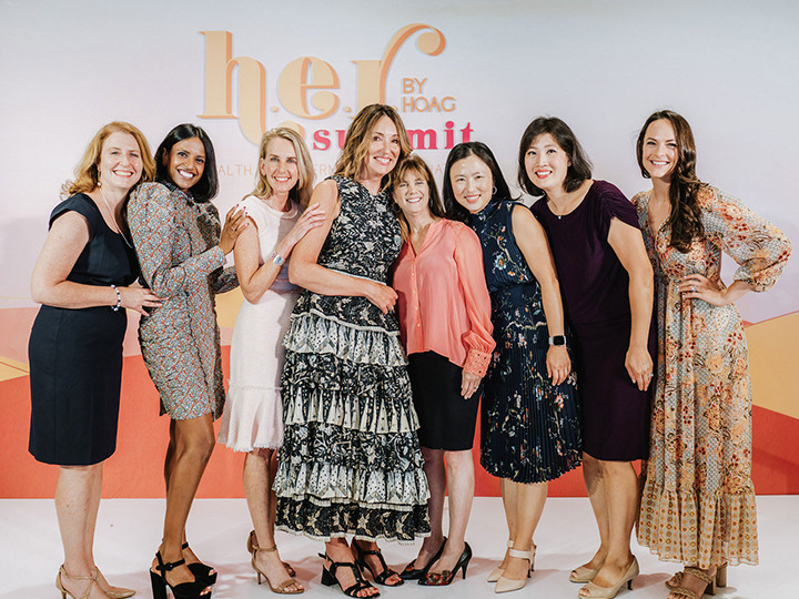 A press image of those participating in the HER summit event