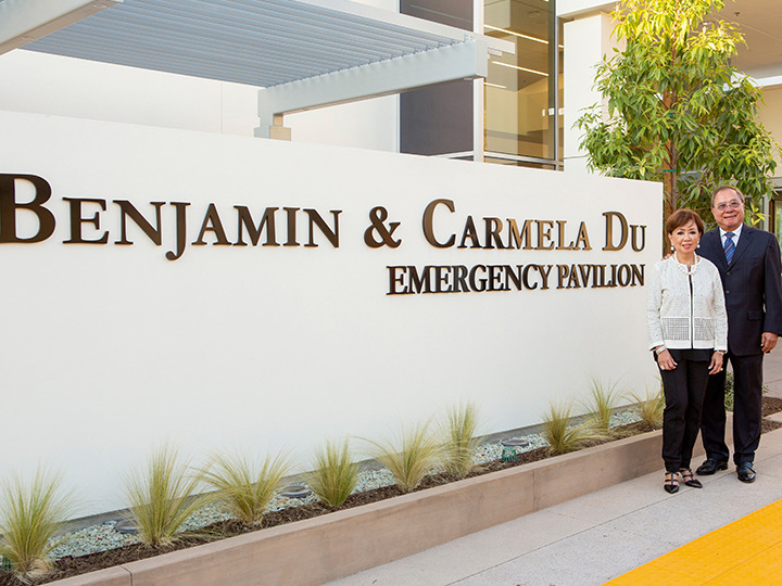 Ben and Carmela Du posing with the signage commemorating their gift
