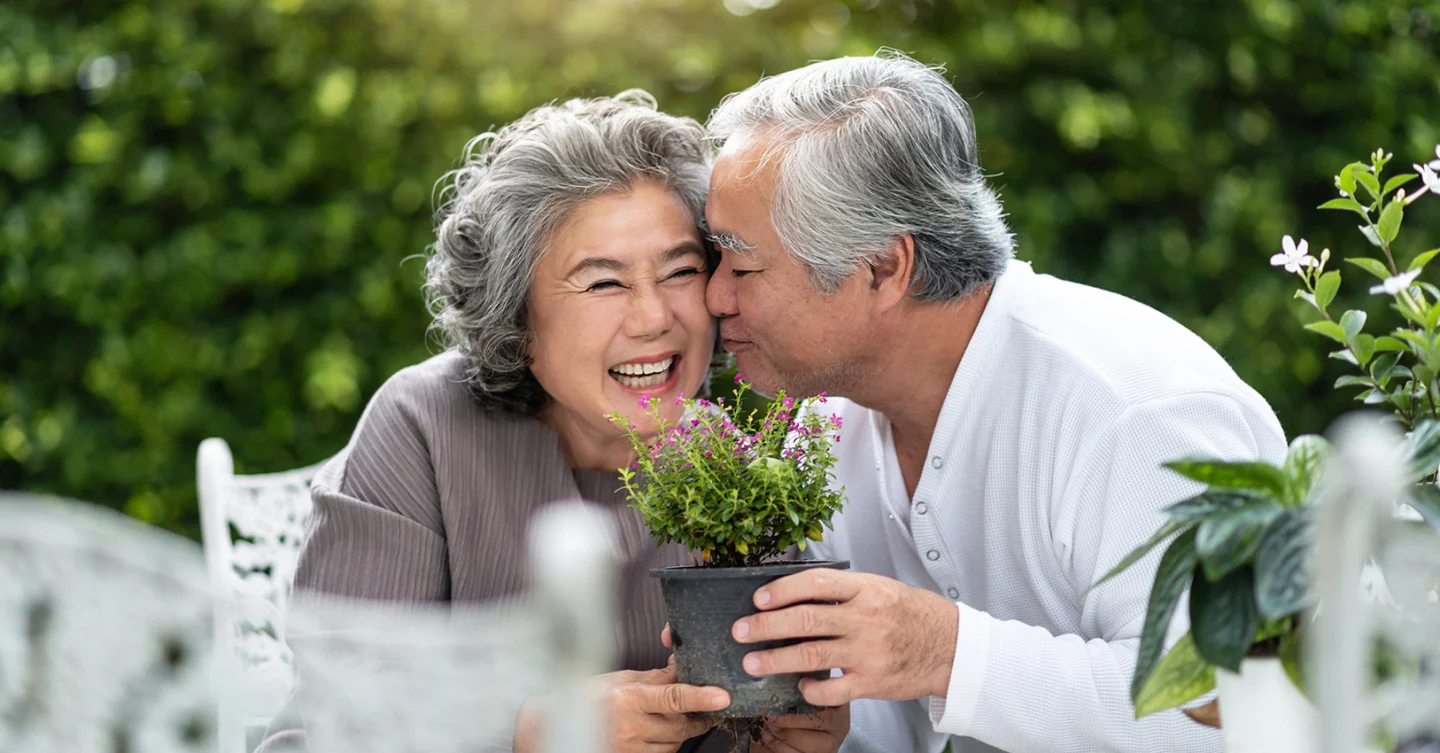 Happy couple smelling flowers