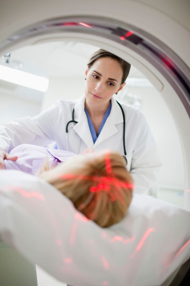Doctor sending female patient through MRI