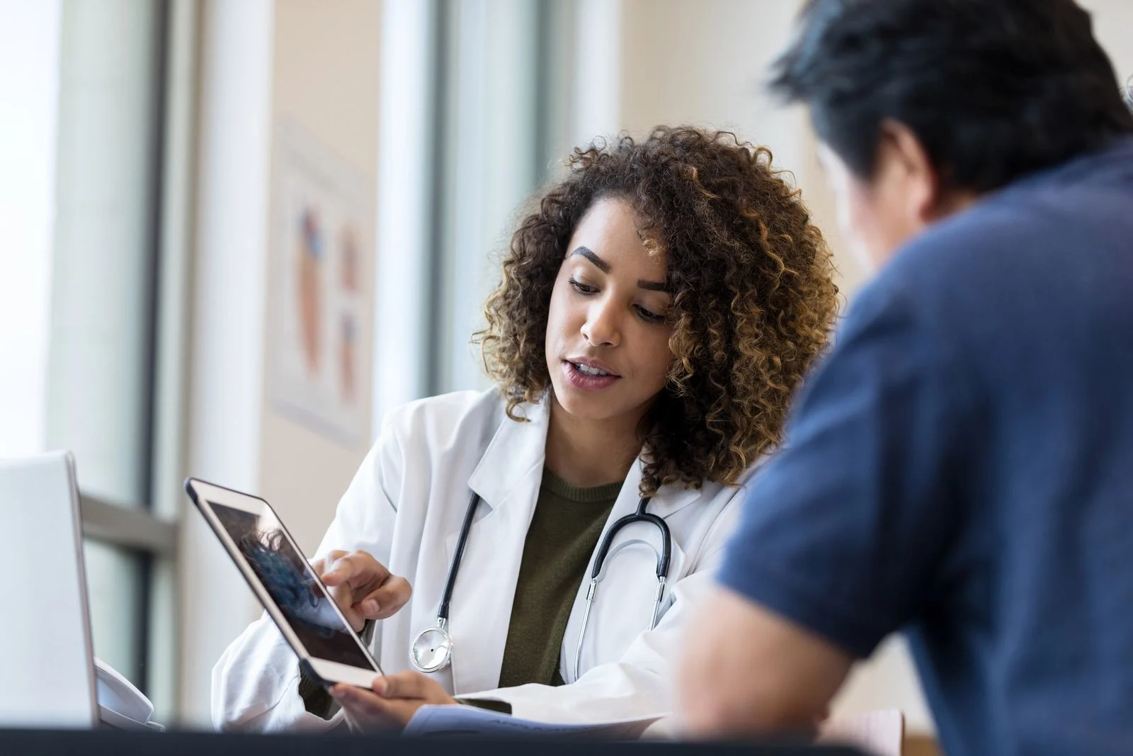 A doctor shows a potential treatment option to a patient