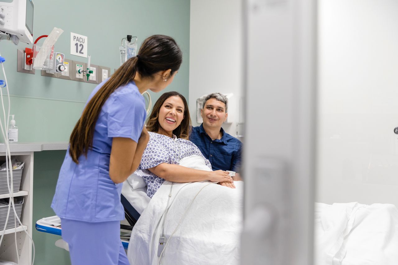 Woman and partner greeted by medical professional
