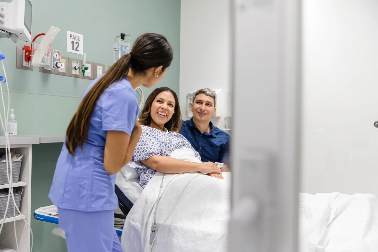 Woman and partner greeted by medical professional