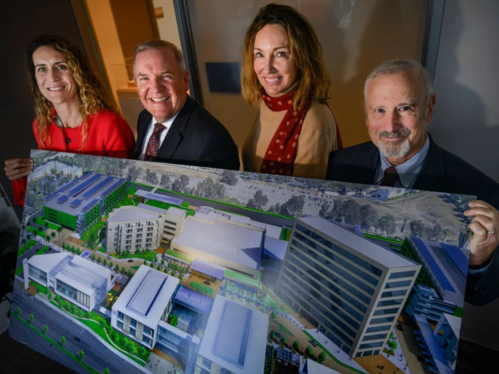 Hoag executive posing with a mockup of the Irvine center