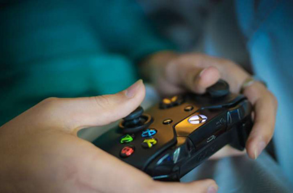 A teen is using an X-box controller