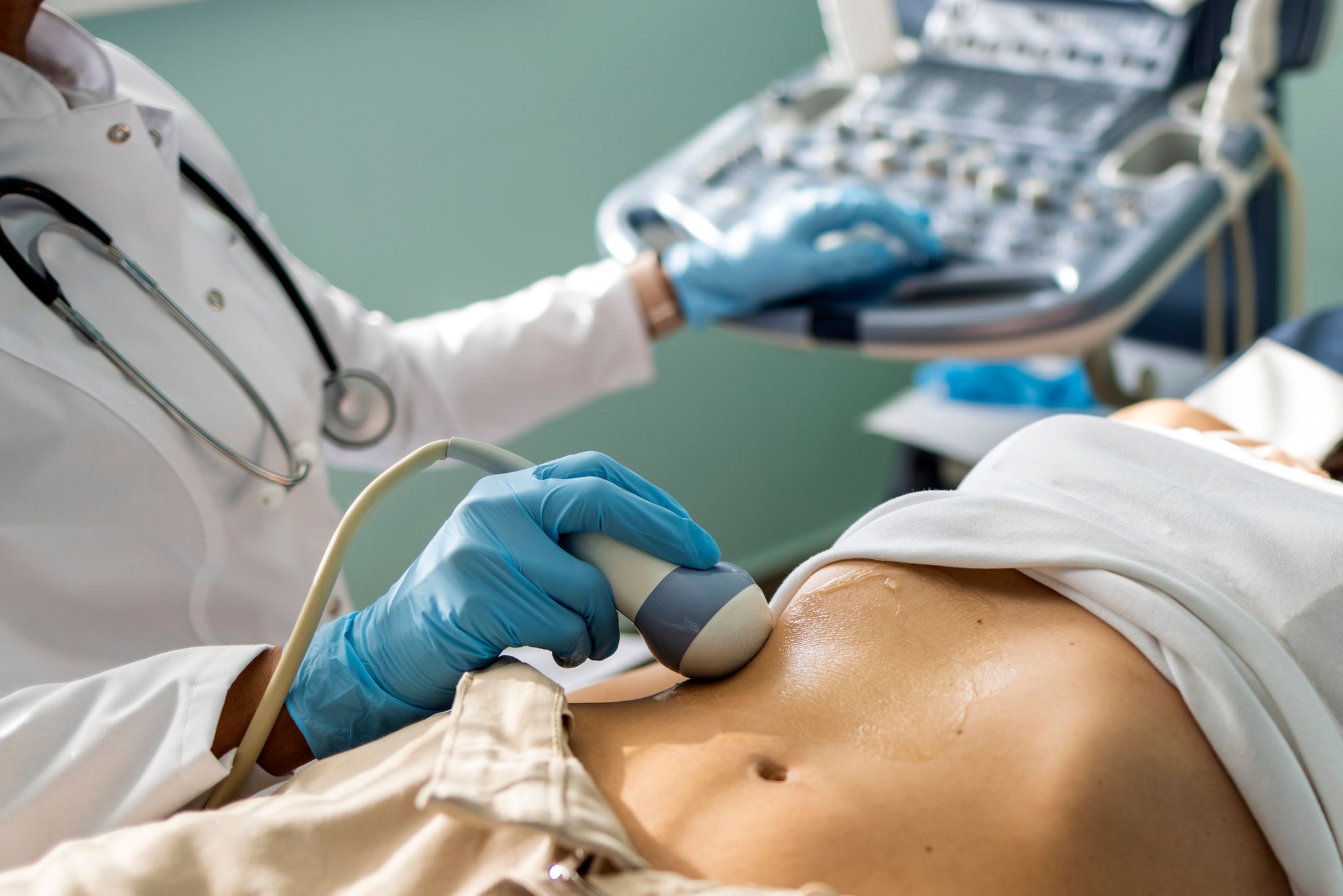 A doctor performs a test on a patients stomach