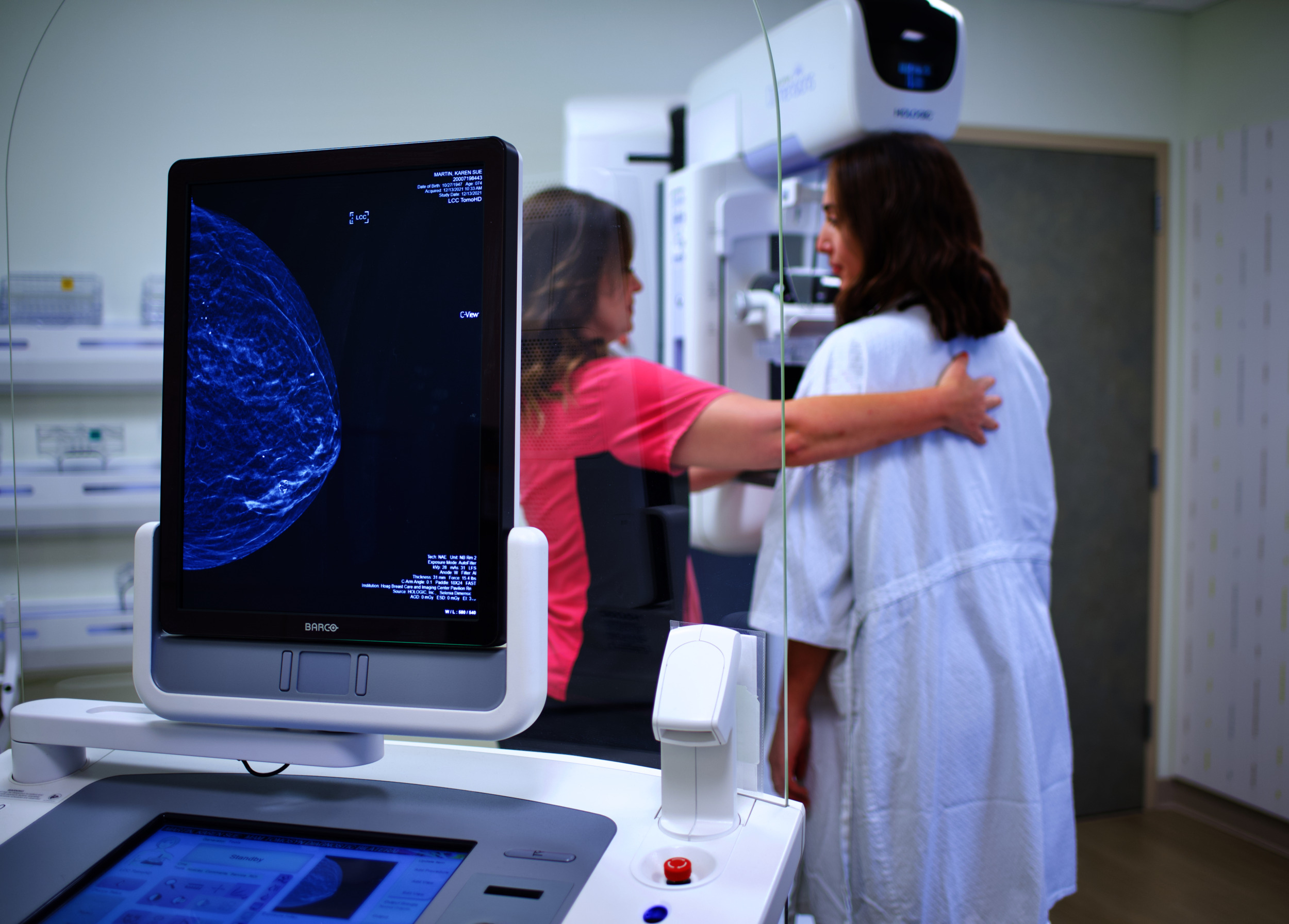 A doctor performs a mammogram on a woman