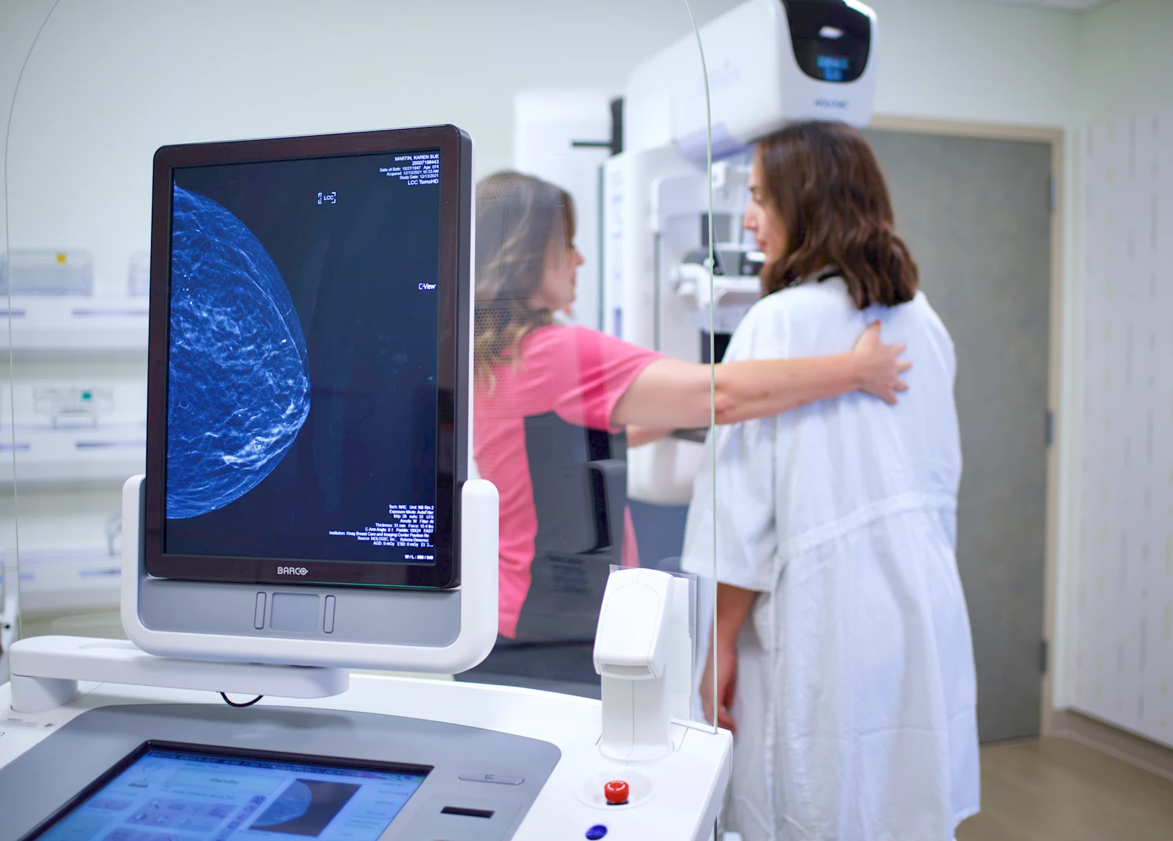 A doctor performs a mammogram on a woman