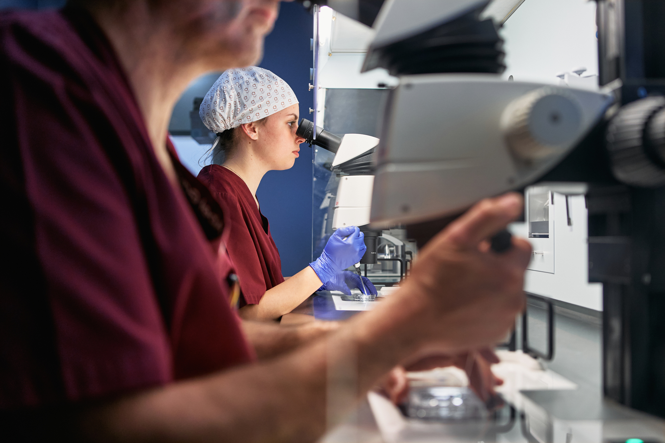 Doctors looking in microscope