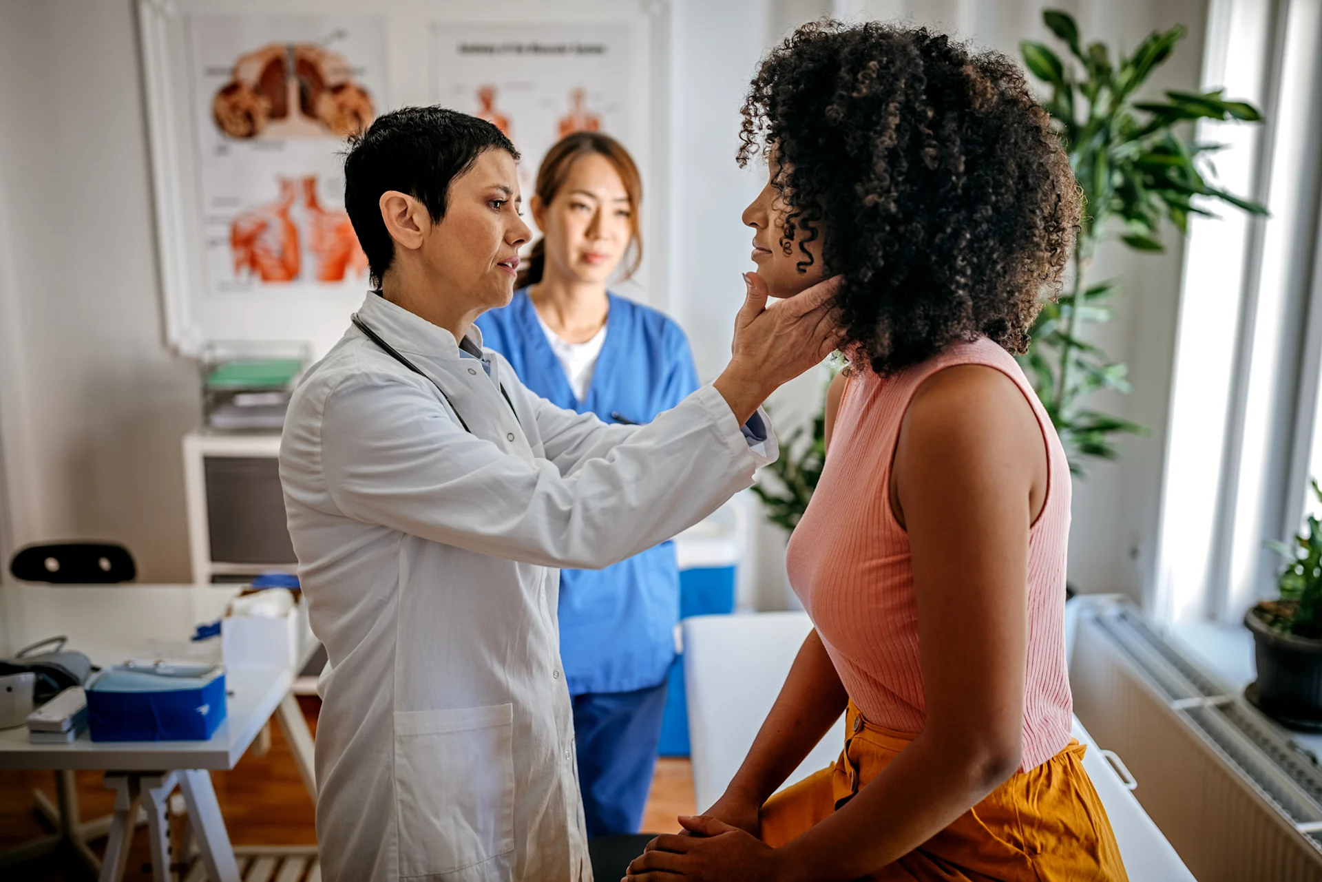 Woman receiving throat exam from physician