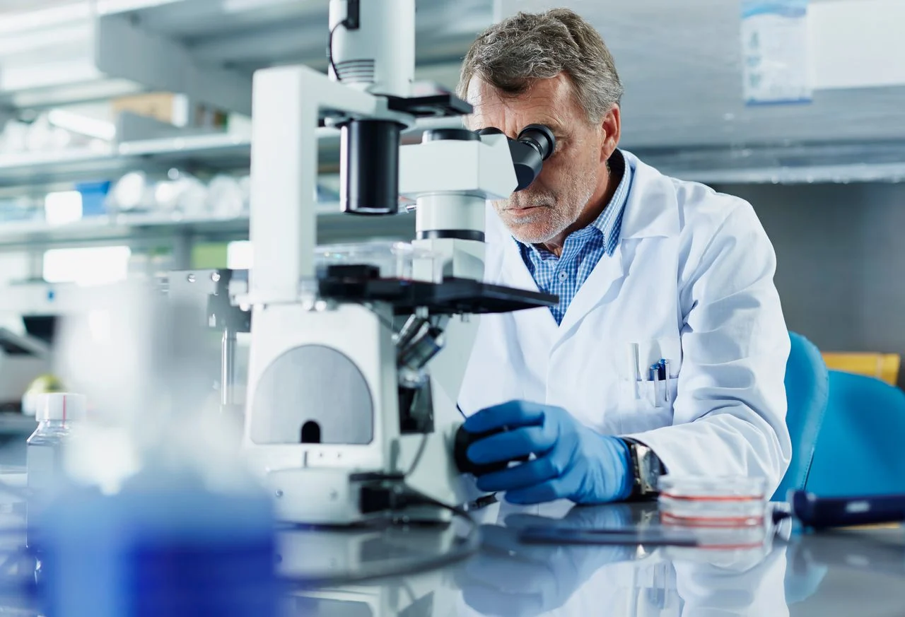 Doctor looking through microscope