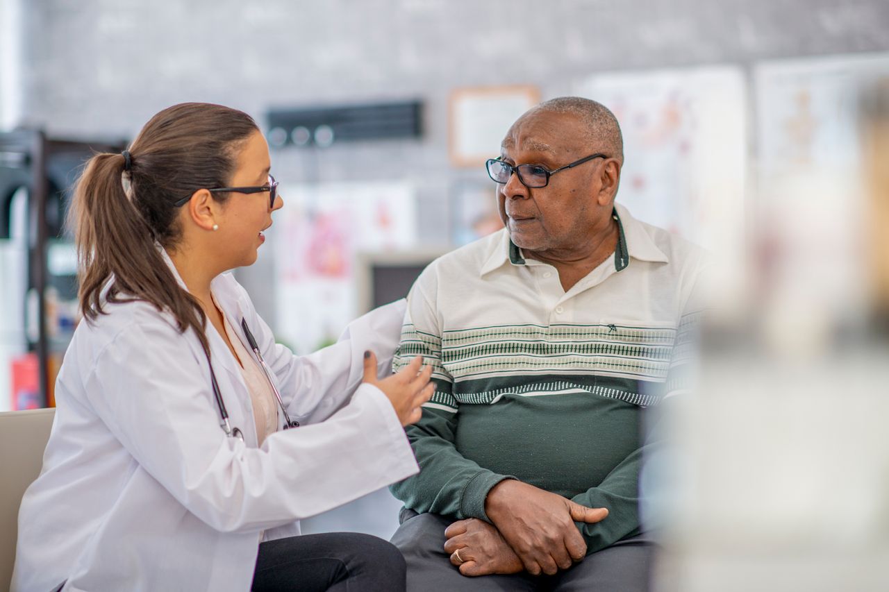 Doctor comforting elderly black man
