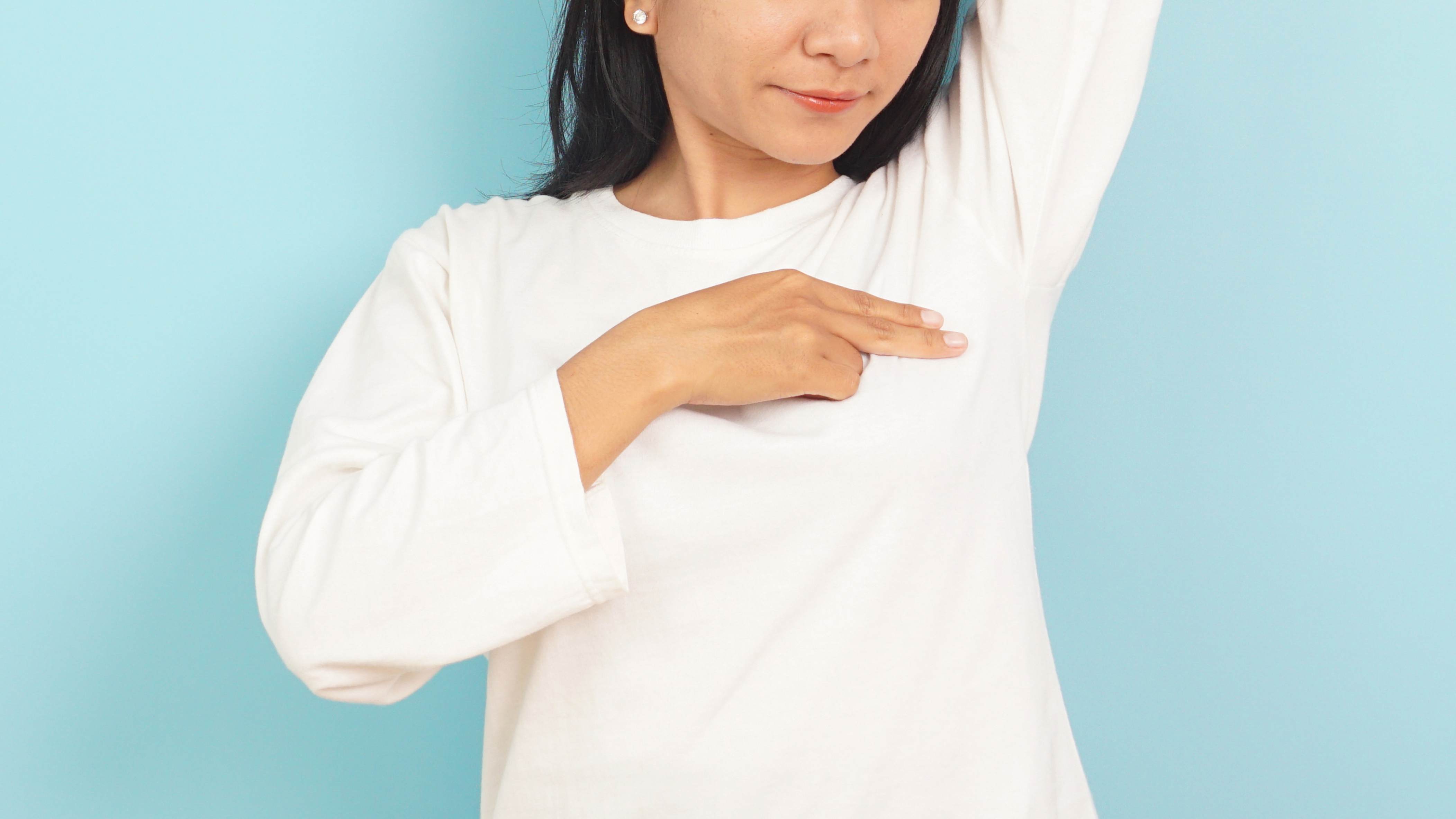 A woman checks herself for breast cancer