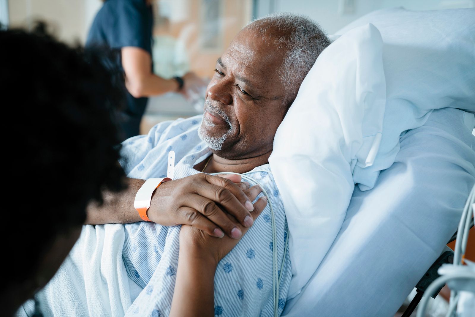 A doctor places her hand on a patient's shoulder