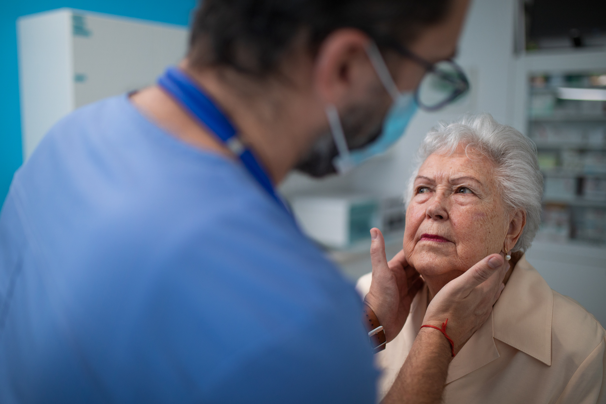 Checking elderly woman's throat glands