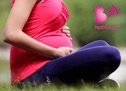 Pregnant woman sitting holding stomach