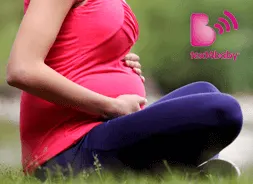 Pregnant woman sitting holding stomach