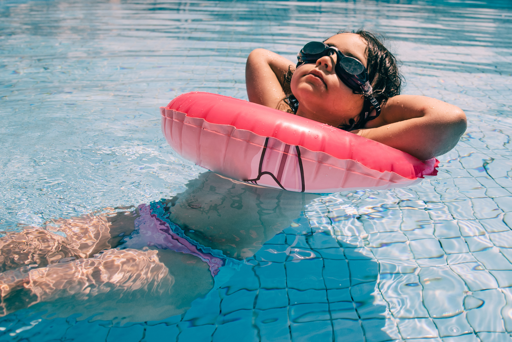 cool little girl in bikini and swim swim glasses relaxing swimming pool