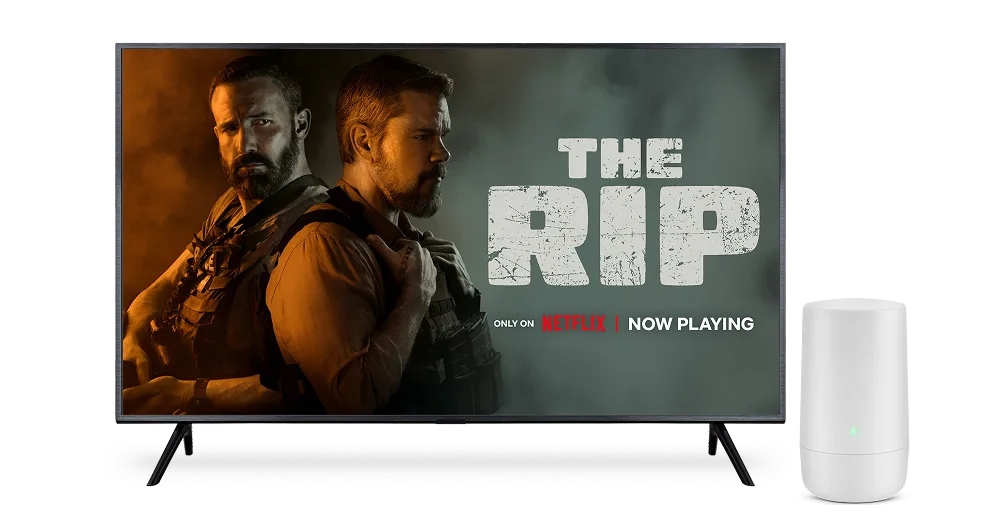 A TV displaying The Rip on Netflix with an Internet router next to it.