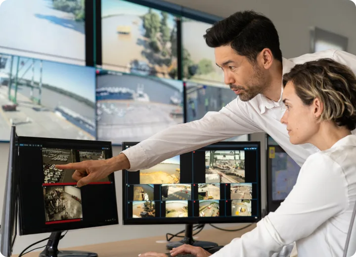 Two security personnel reviewing security footage.