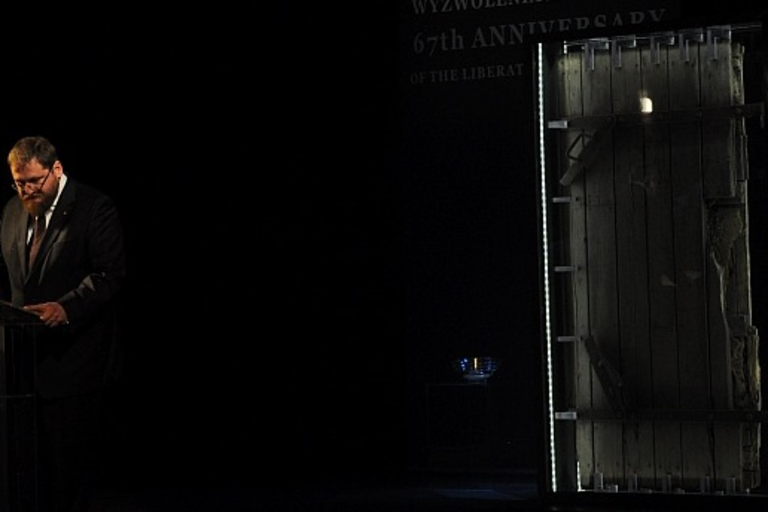 Петр Цивиньский на фоне двери газовой камеры. Фото: Павел Савицкий / Музей Аушвиц-Биркенау 
