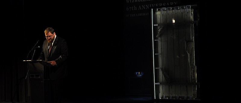Петр Цивиньский на фоне двери газовой камеры. Фото: Павел Савицкий / Музей Аушвиц-Биркенау 