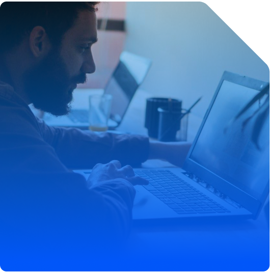 Stock image with a blue gradient overlay showing a man reading a report on his laptop