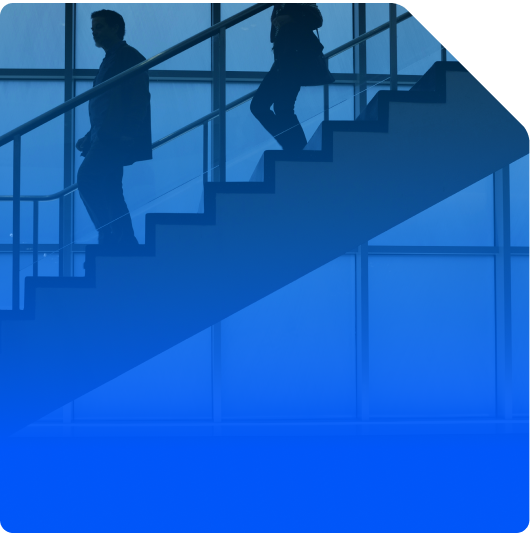 Graphically enhanced image with a blue gradient overlay showing two business people walking down the stairs in an office building