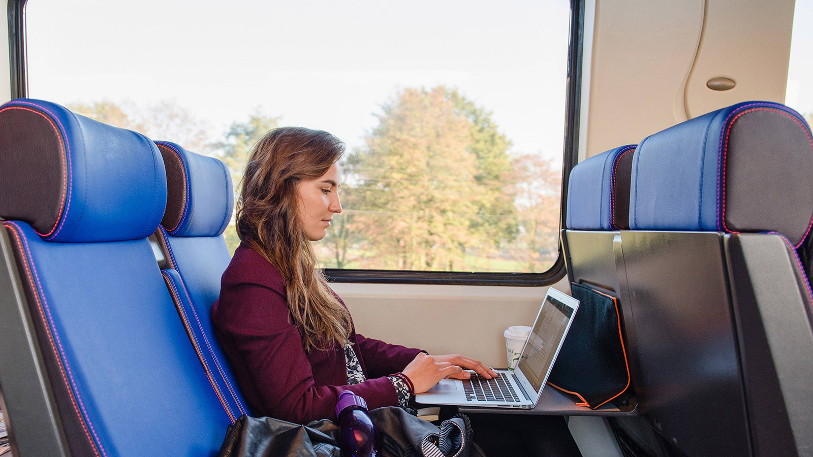 Vrouw met laptop in de trein