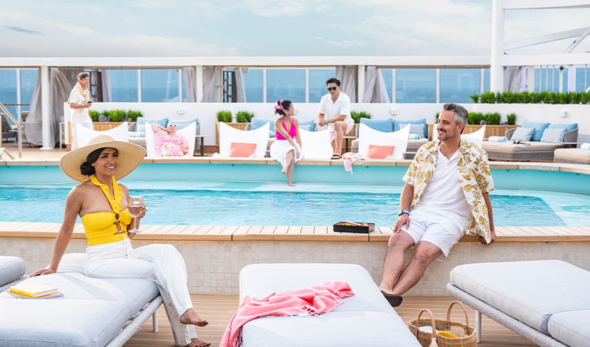 Princess Cruises® - Couples lounge with drinks by the cruise ship pool