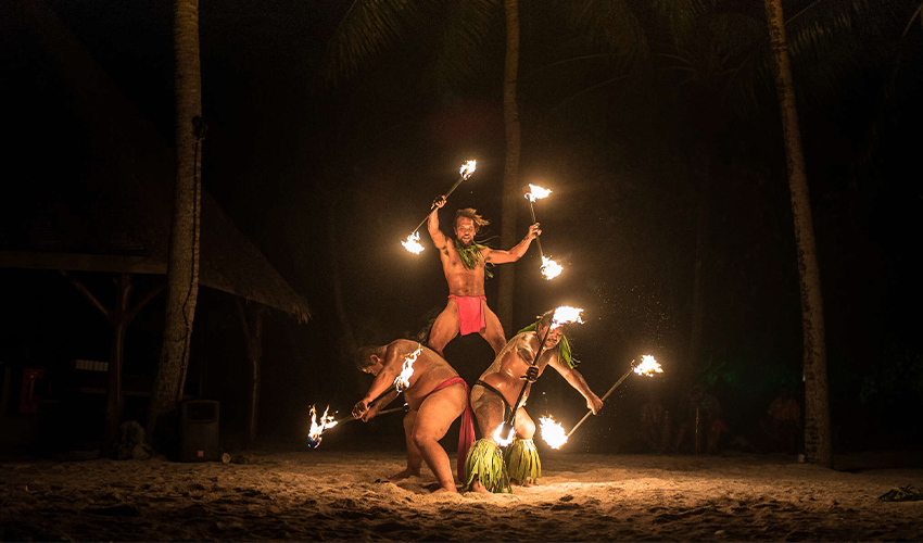 Windstar Cruises: Three traditional Tahitian fire dancers performing at night 