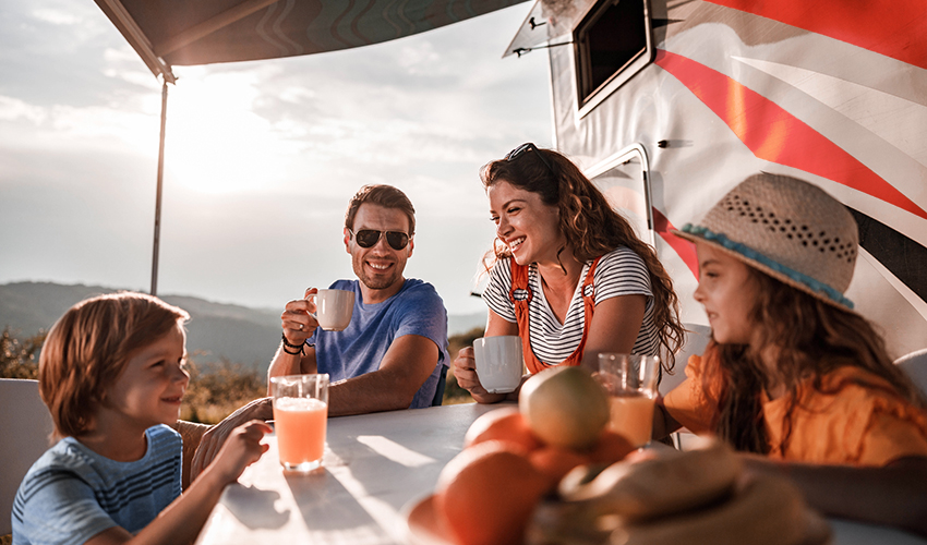 family-of-four-having-juice-and-coffee-outside