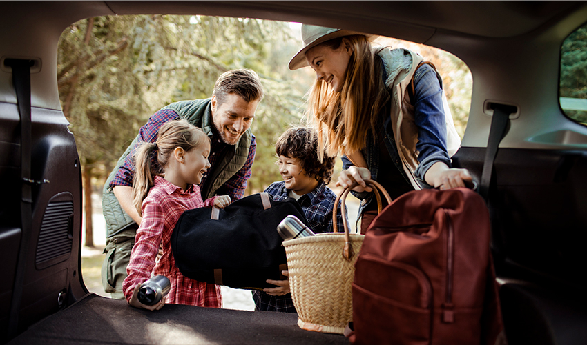 Parents with two kids pack for a day trip