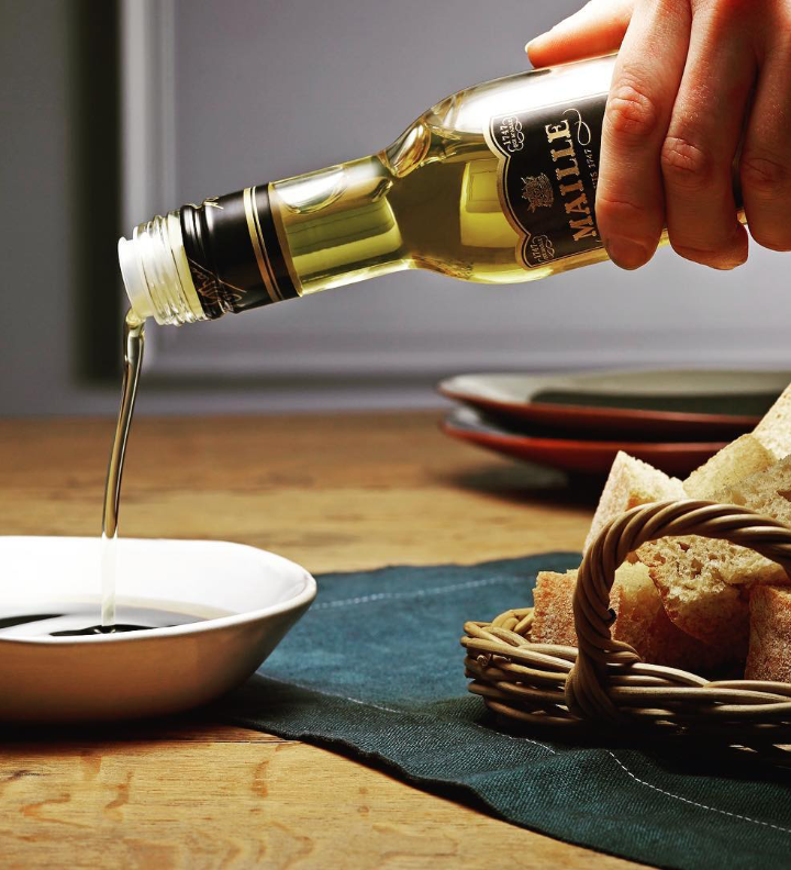 Maille's Olive oil being served onto a white dish