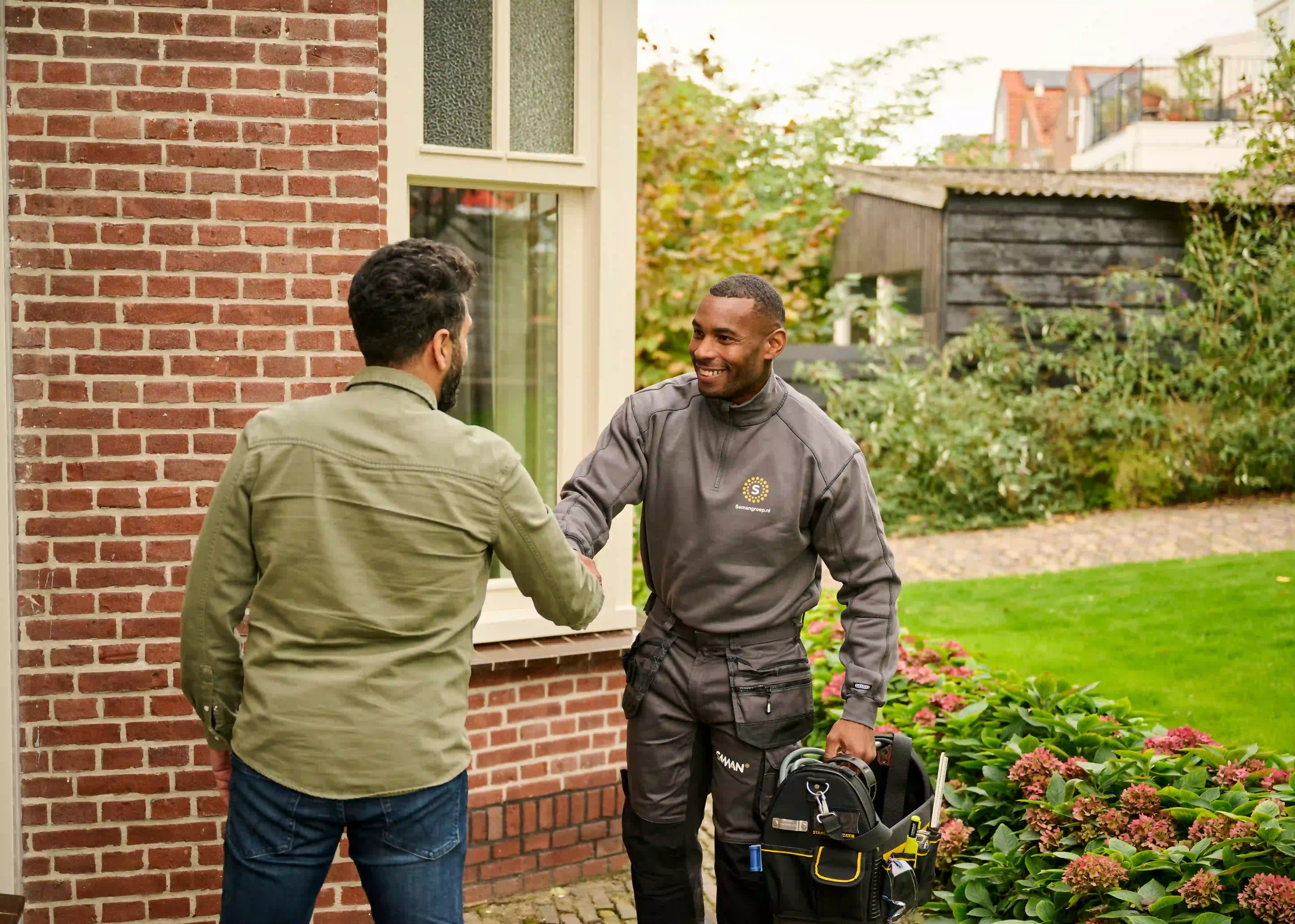 Saman groep monteur geeft hand aan een klant en lacht