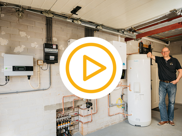 Klant staat blij naast zijn installatie van een warmtepomp en een video play button