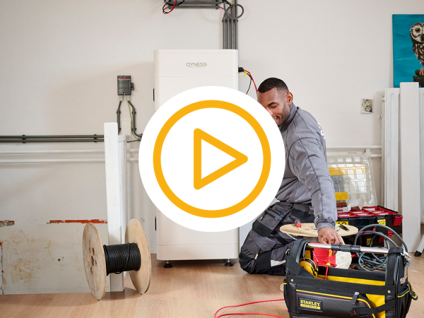 Saman monteur die een thuisbatterij de dyness tower pro installeert op een zolder kamer en een video play button